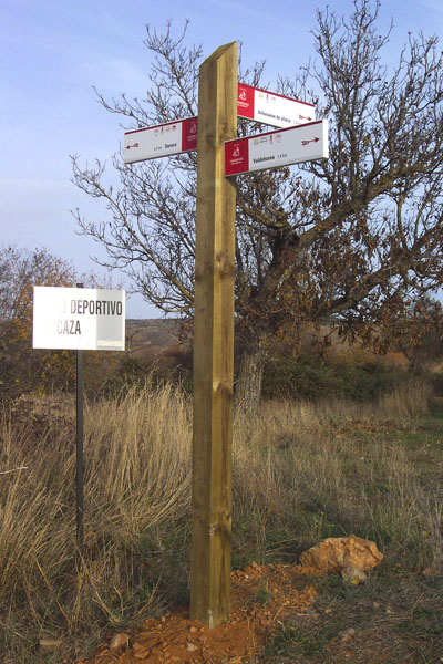 Señalización | Flecha direccional triple para señalización de senderos, fabricada en metal sobre poste de madera tratada. © UTM Desarrollos