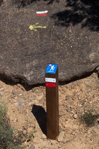 Señalización | Baliza direccional de sendero de Gran Recorrido (GR) con marcas de color en planchas de metal pintadas y placa identificativa en testa abiselada. © UTM Desarrollos